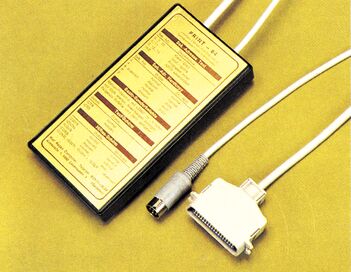 PRINT-64 Centronics-Interface: kleines schwarzes Gehäuse mit DIP-Schaltern, Commodore- und Centronics-Anschlusskabel