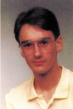 Porträtfoto einer Person mit Brille und hellem Polohemd