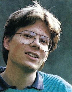 Porträtfoto einer Person mit Brille und hellblauem Pullover