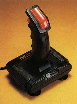 Joystick mit rotem Griff und schwarzem Sockel auf gelbem Grund