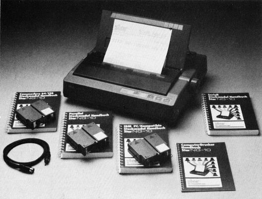 Schwarzweißfoto: Nadeldrucker mit eingelegtem Papier, davor vier Handbücher mit Schnittstellen-Modulen und ein Kabel