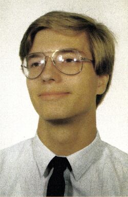 Porträt eines jungen Mannes mit Brille, weißem Hemd und dunkler Krawatte