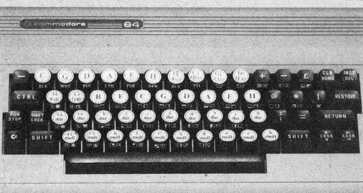 Foto einer C-64-Tastatur, auf deren Tasten runde Aufkleber mit Buchstaben und Akkordbezeichnungen kleben