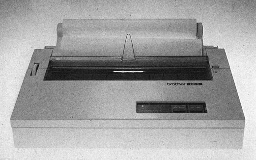 Foto: heller Drucker mit aufgesteckter Papierrolle und Bedienfeld vorne rechts, Aufschrift »brother«